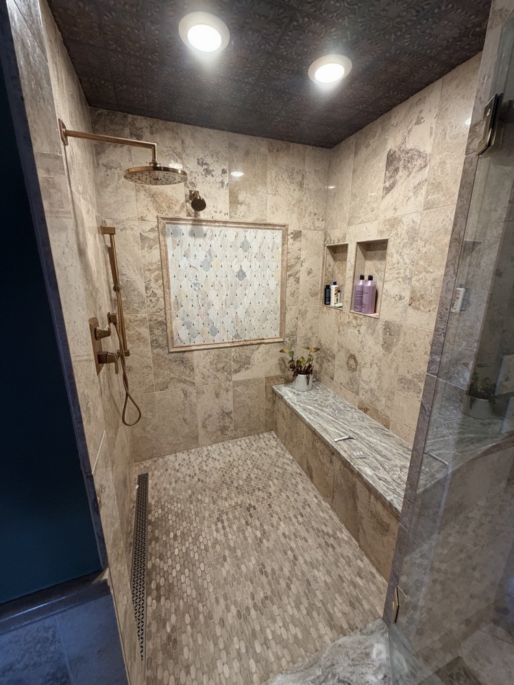 After: travertine walk-in shower with bench and wood plank ceiling, West Alexandria, OH
