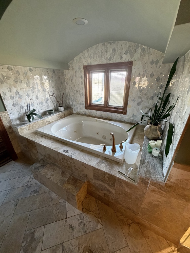After: garden tub with a tiled stone surround under an arched window, West Alexandria, OH