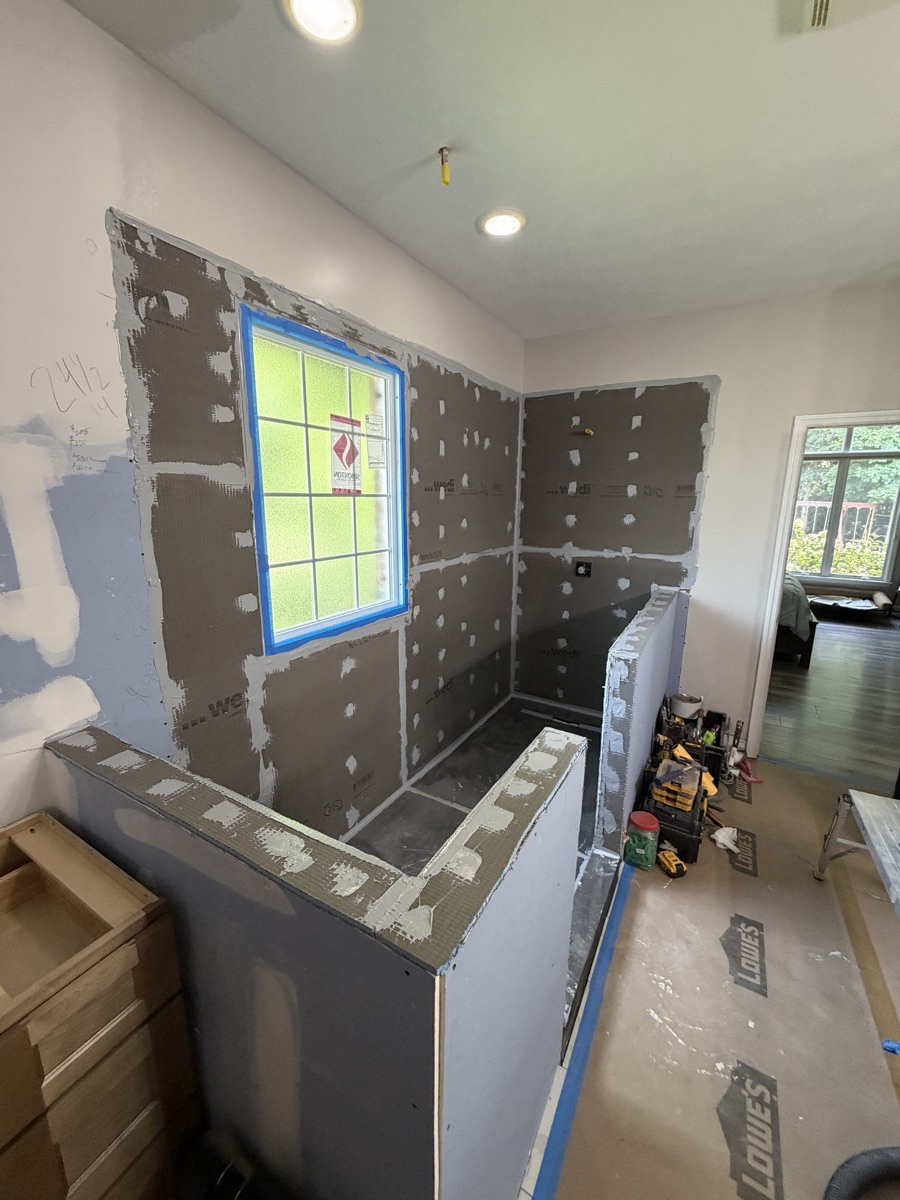 Shower walls, half walls and window opening covered in waterproof board with sealed seams