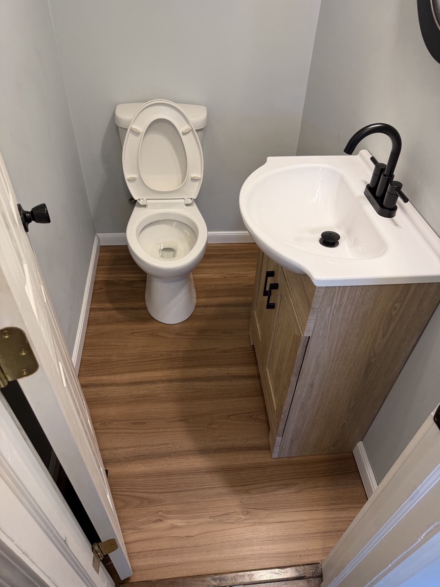 Half bath with a wood vanity, matte black faucet and matte black towel ring in Beavercreek, OH