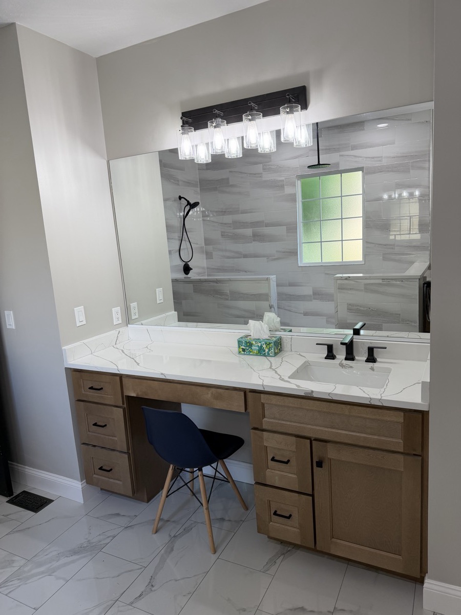 Wood double vanity with a quartz top and matte black faucets in an Eaton, OH master bathroom