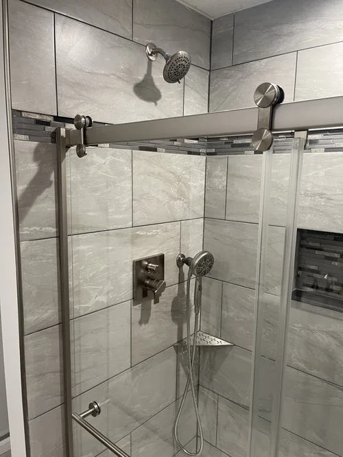 Walk-in shower with gray tiled walls