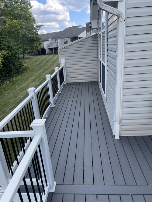 Gray wooden balcony with white and black railing