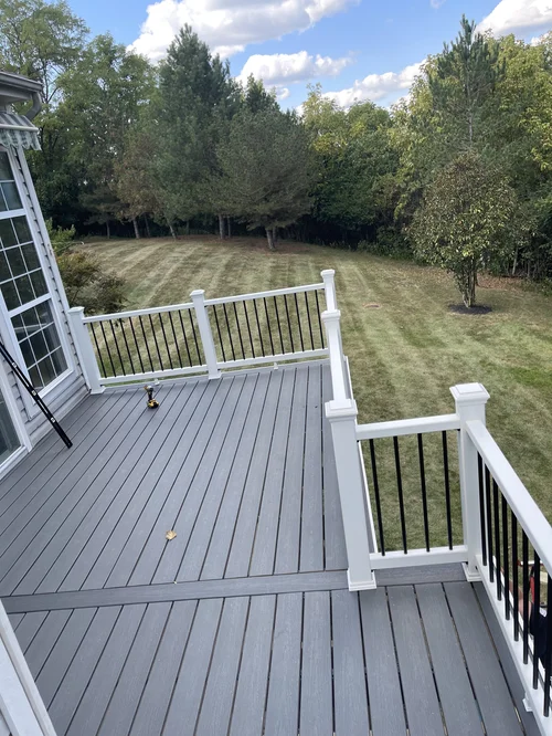New gray deck with black and white railing overlooking a backyard with a grassy lawn, Cincinnati, OH
