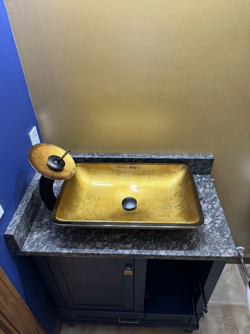 Gold vessel sink with black waterfall faucet on a granite vanity top, West Alexandria, OH