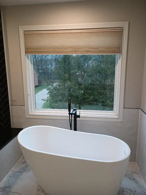 White bathtub with black faucet
