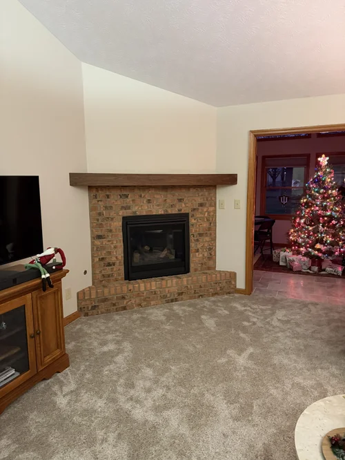 Brick fireplace before its new walnut mantel