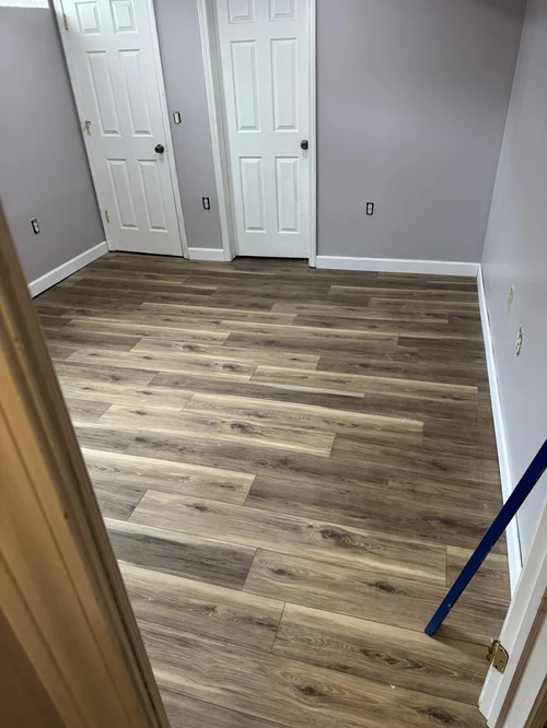 Room with new wood-look laminate flooring and white trim