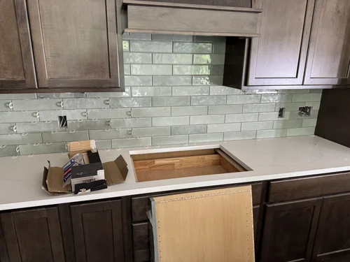 Kitchen with dark wood cabinets and green subway tile backsplash