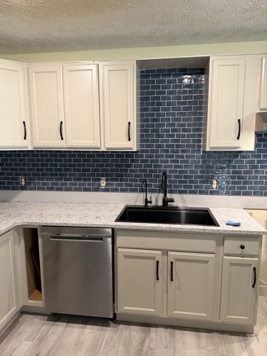 Navy glass subway tile backsplash behind a black farmhouse sink, Dayton, OH