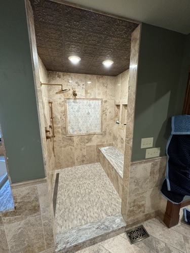 Travertine walk-in shower with mosaic medallion, bench and wood plank ceiling, West Alexandria, OH